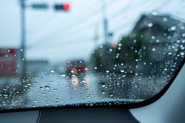 梅雨の日に車の窓ガラスについた雨粒