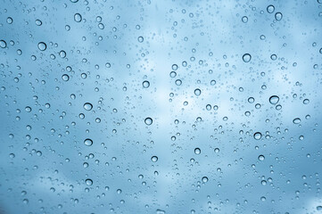 梅雨の日に車の窓ガラスについた雨粒