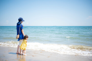 夏の海の砂浜と青い空と親子