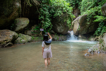 Fototapeta premium A vacation to a waterfall in the middle of the forest in the high valley.