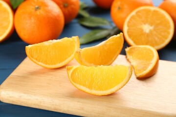 Slices of delicious ripe oranges on wooden board, closeup
