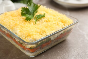 Traditional russian salad Mimosa served on marble table, closeup