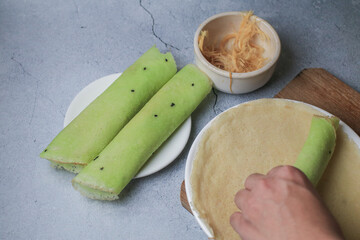 Hand roll Thai cotton candy burrito pancake or Roti Saimai, thin sheet of wheat flour wrapped in...