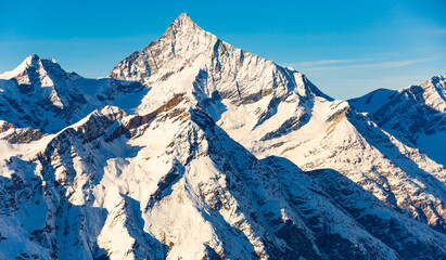 Impressive winter alpine landscape near Zermatt with rocky snow covered mountain slopes on...