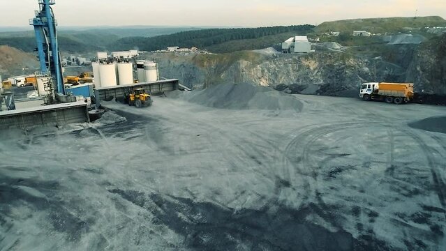 Aerial view of wheel loader working on construction site. Wheel bulldozer loading soil in scoop.