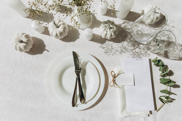 Thanksgiving table setting, tableware and decorations. Blank white postcard on table mockup, top view