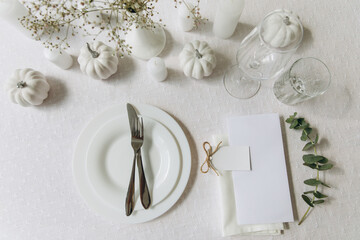 Thanksgiving table setting, tableware and decorations. Blank white postcard on table mockup, top view