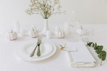 Thanksgiving table setting, tableware and decorations. Blank white postcard on table mockup.