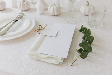Thanksgiving table setting, tableware and decorations. Blank white postcard on table mockup.