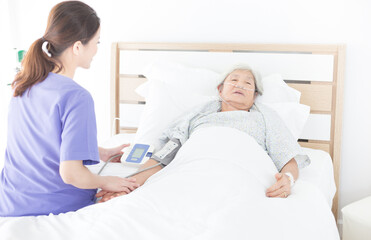 nurse measure blood pressure old asian patient , elderly health check up , palliative care