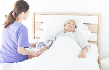 Obraz premium nurse measure blood pressure old asian patient , elderly health check up , palliative care