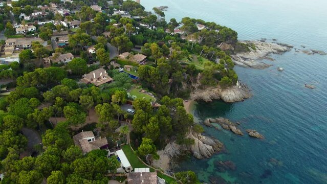 Gorgeous bay, Coastline, round pool.Marvelous aerial view flight tilt down drone footageat sunset golden houre evening in spain aro beach summer 2022.