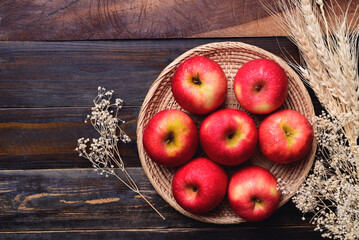 Red apple fruit in basket on wooden background, Table top view