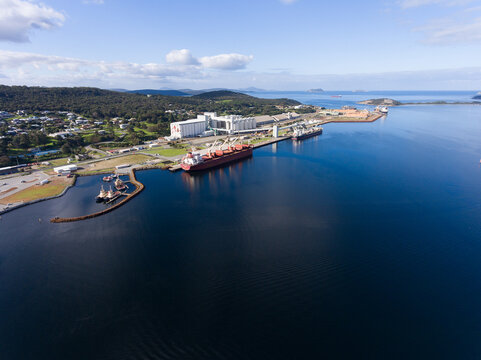 Bulk grain carrier berthed at Albany port with grain silos and tug boats
