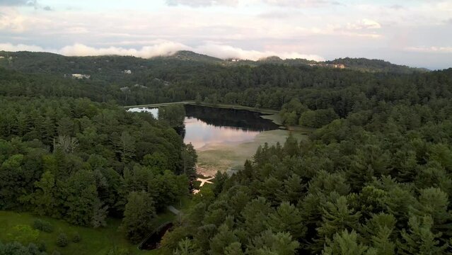 aerial fast puch over treetops into bass lake in blowing rock nc, north carolina near boone nc
