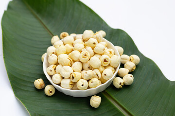 Dried lotus seeds on green leaf