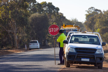 roadworker near work ute with stop sign