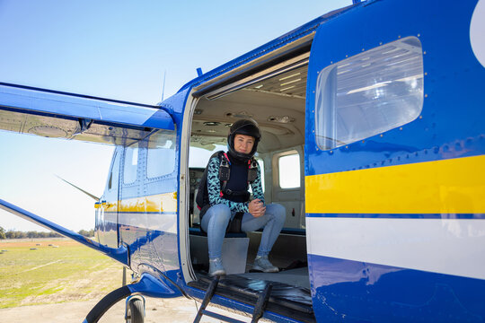 Skydiver Wearing Helmet Sitting In Plane With Door Open