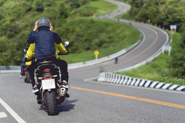 A man and a woman ride together on a sports motorcycle. Motorcyclists travel around the city during the day on a touring bike.