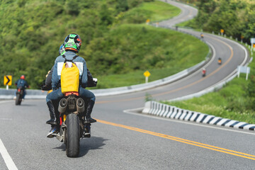 A man and a woman ride together on a sports motorcycle. Motorcyclists travel around the city during the day on a touring bike.