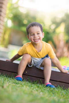 Young boy happily sitting on deck next to his eggs after easter egg hunt.