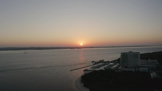 Beautiful sunrise in Setúbal City. Flying above the water with a stunning coastline view of the Troia island.