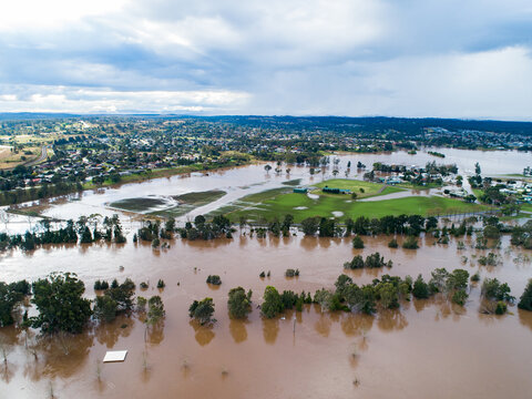 Patch of farmland paddock cut off by floodwater aerial view over flood and river