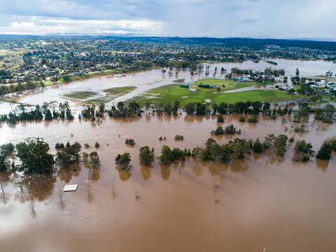 Patch of farmland paddock cut off by floodwater aerial view over flood and river