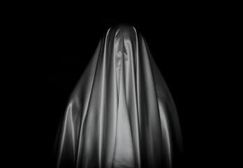 Scary white ghost sheet on black background for Halloween Festival concept.
