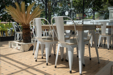Fototapeta na wymiar Real photo of a dining table with white chairs set on the terrace