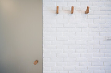 wooden hanger hook on white brick wall