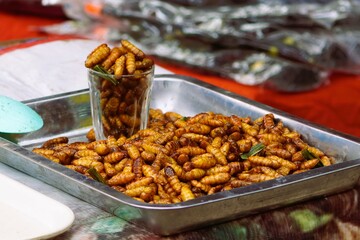 Fried insects, stack them together and put them in a glass of water to wait for sale.