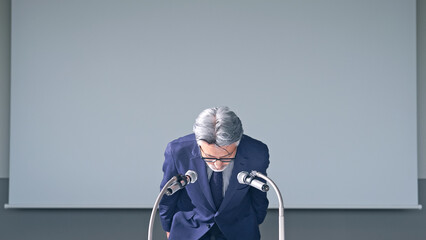 謝罪会見するエグゼクティブ男性