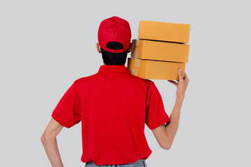 Young asian man in uniform red and cap standing carrying box stack isolated white background,...