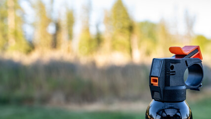 Aerosol trigger of a can of bear spray in an outdoor setting