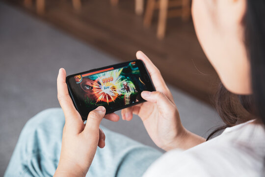 Young woman playing online game on smart phone.