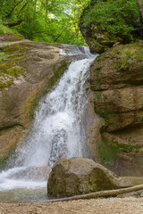 Naklejka premium A mountain river in a natural channel with rapids and waterfalls in the bosom of nature.