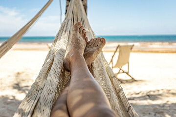 Woman's legs in the hammock against the ocean view