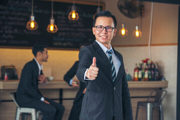 Asian businessman holding hand thumbs up satisfaction job with positive happy good sign. Portrait businessman hand positive good idea happy business. Gesture sign Thumbs up smile face look at camera