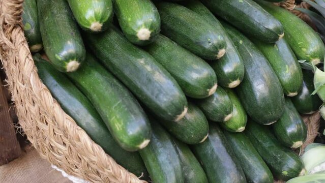 Bunch of ripe green zucchinis in wicker basket. Vegetables for sale.