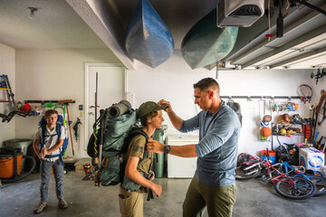 Naklejka premium Air Force service member organizes gear with his sons before a backpacking trip.