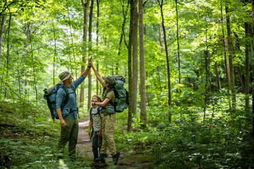 Fototapeta premium Air Force service member heads out on a hike with his sons on a backpacking trip.