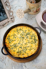 fried omelet in a pan on a white background with tea vertical photo
