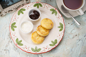 breakfast cheesecakes in a white old woman on the table with tea
