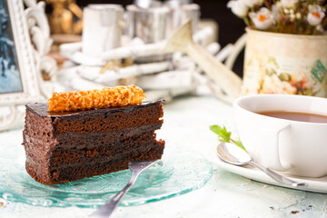 dessert chocolate cake on a transparent plate on the table with tea
