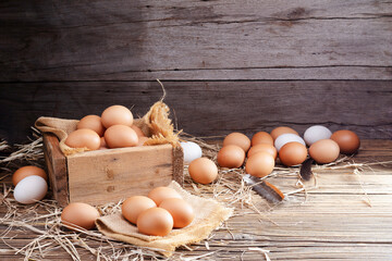 Chicken eggs are laid on the ground and put in a basket on a wooden table on, a rural farm
