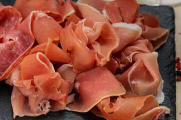 Jamon cut into slices in a plate, macro photo
