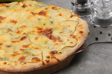 crusty and cheese pizza with side dish on a gray background with toppings
