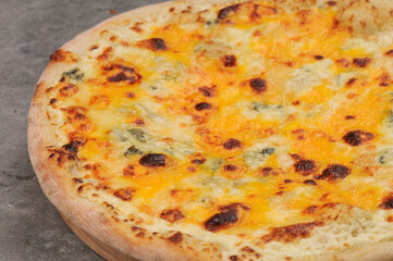 pizza with four cheeses with side dish on a gray background macro photo
