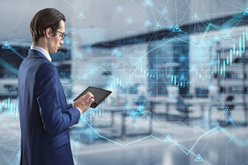 businessman using tablet with abstract glowing forex chart, map and arrows on index hologram, blurry office interior background. Trade, financial growth, analytics and market concept. Double exposure.
